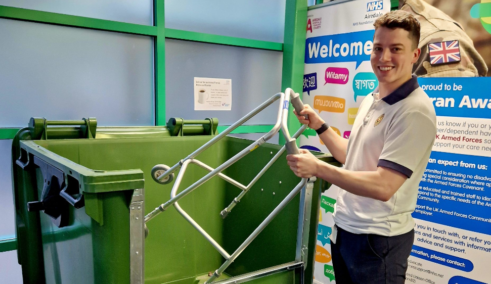 Photograph of a person putting a walking aid into one of the recycling bins