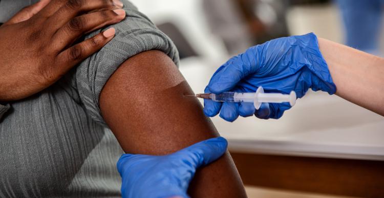Man receiving COVID vaccine in his arm