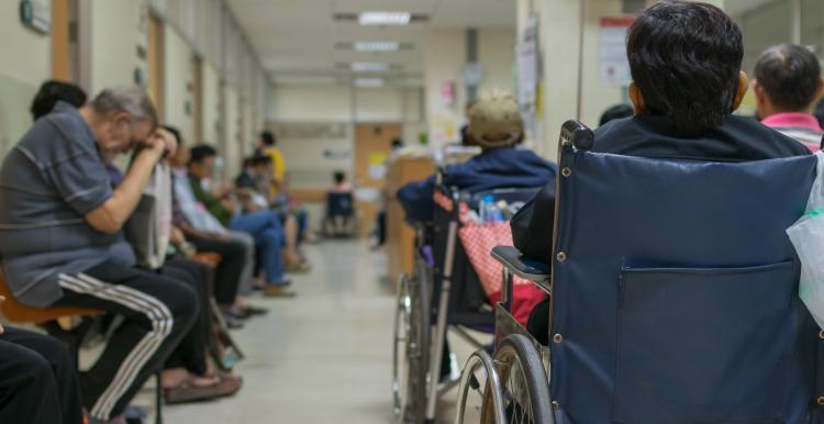 A photograph of patients waiting in a busy hospital corridor