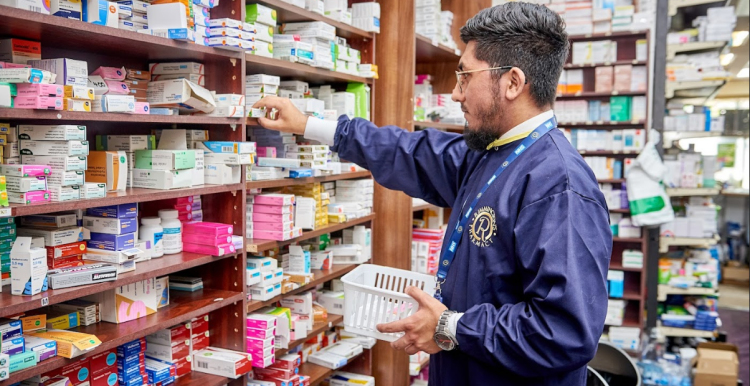A photograph of a pharmacist selecting an item from a shelf