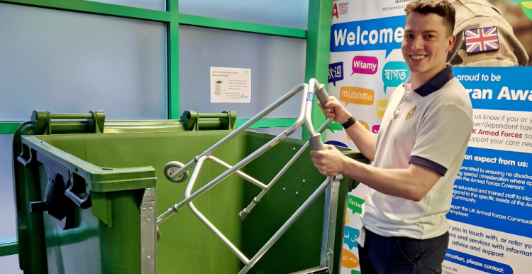 Photograph of a person putting a walking aid into one of the recycling bins