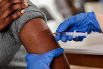 Man receiving COVID vaccine in his arm