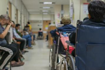 A photograph of patients waiting in a busy hospital corridor