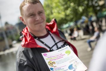 man taking a healthwatch leaflet